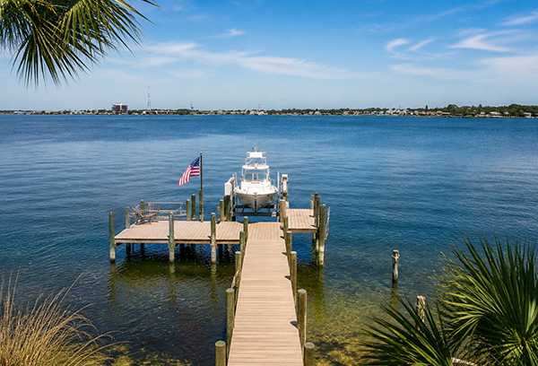 Waterfront dock and boat on Poquito Bayou in Shalimar Florida overlooking calm bay waters